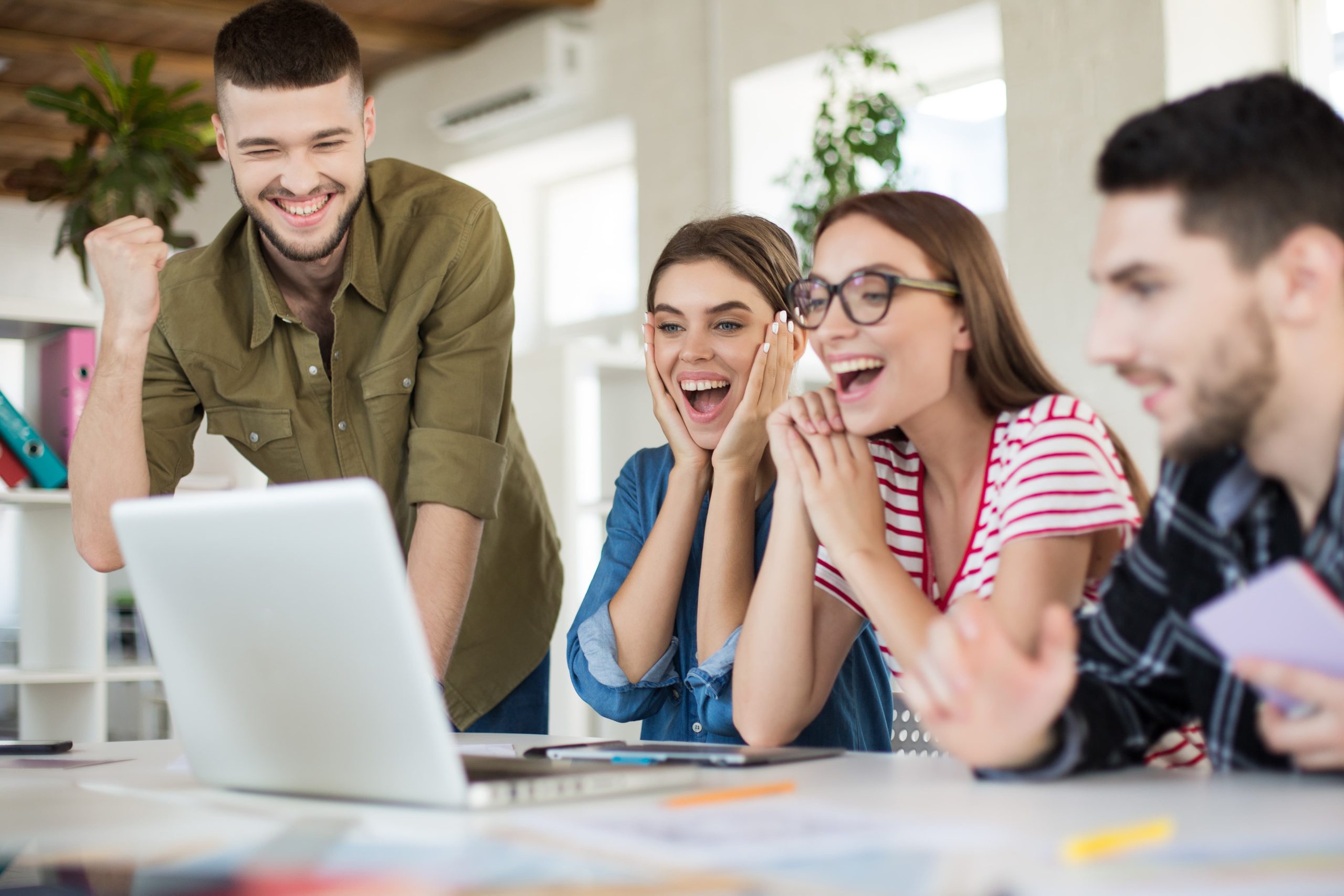 Grupo de jovens profissionais colaborando em escritório moderno, representando o que o mercado espera do recém-formado no primeiro emprego.